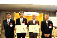 表彰状を手にする鈴木伸一常務執行役員（中央左）と近藤成俊タイヤ販売物流部長（左端）