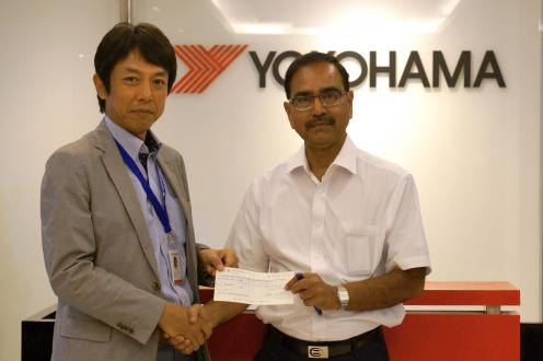 YIN President Satoshi Fujitsu presenting donation check to Indian Red Cross Deputy Secretary Mr. P.C. Partihari (right) 