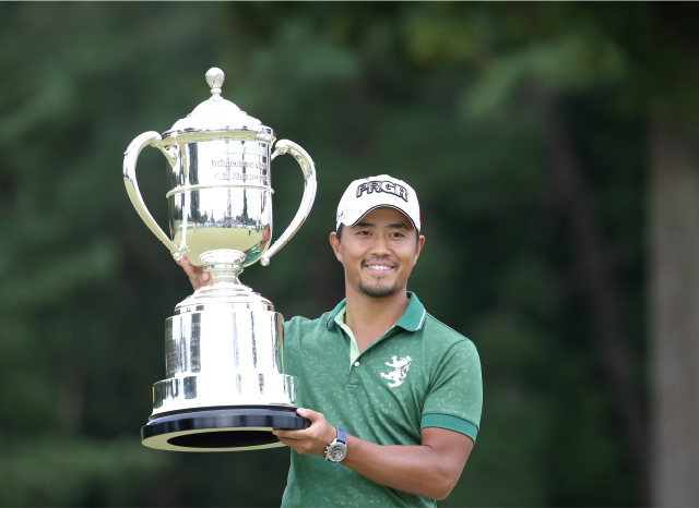 優勝トロフィーを掲げる小平智選手