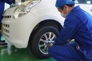 当社の乗用車用タイヤを被災者への寄贈車両に装着する石巻専修大学の学生