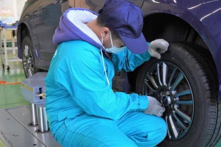 当社の乗用車用タイヤを寄贈車両に装着する石巻専修大学の学生