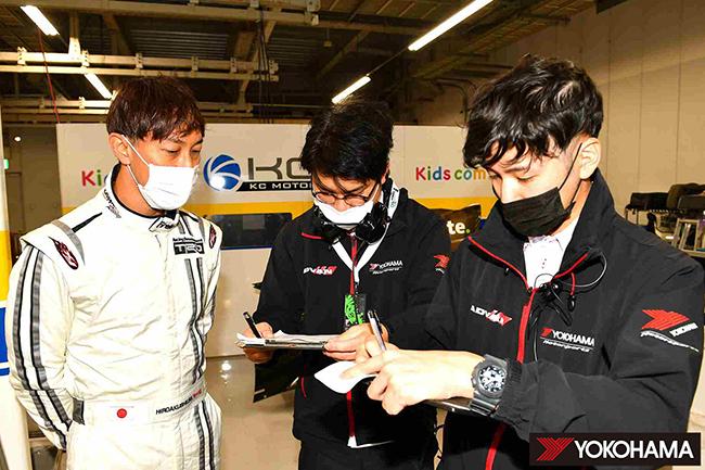 Test driver Hiroaki Ishiura (left) speaking to Yokohama Rubber tire development staff