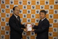 ＷＷＦジャパンの樋口隆昌事務局長（左）に募金の目録を手渡す横浜ゴム取締役兼専務執行役員の小島達成（右）