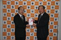 WWFジャパンの樋口隆昌事務局長（左）に募金の目録を 手渡す横浜ゴム取締役常務執行役員の福井隆（右）