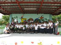 Children holding seedlings donated with pots made from waste rubber materials (at a local school)
