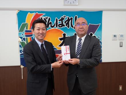 植樹会に先立ち平野公三大槌町長（右）にタイヤ目録を手渡す森睦成環境保護推進室長