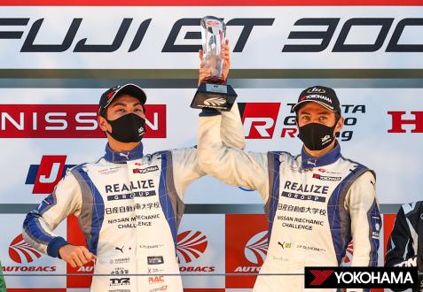 Drivers Kiyoto Fujinami (left) and Joao Paulo de Oliveira on the podium with their championship trophy