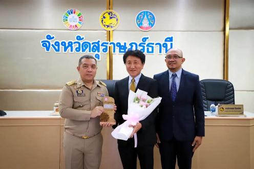 Governor Jumpot Wannachatsiri (left) presents flowers to YTRC Managing Director Noboru Takita (center) and Department Manager Supachai Choosuwan at the Surat Thani Provincial Council.